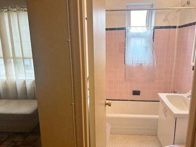 full bathroom featuring tile patterned flooring, vanity, tiled shower / bath combo, and toilet