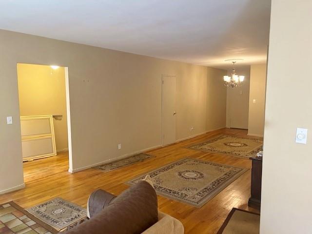 living room with light hardwood / wood-style floors and an inviting chandelier