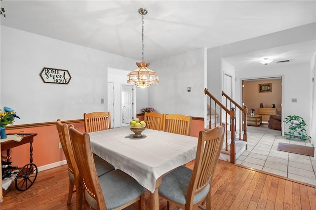 dining area with a notable chandelier and light hardwood / wood-style floors