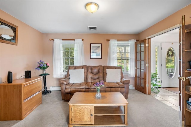 living room featuring light colored carpet, baseboard heating, and a healthy amount of sunlight