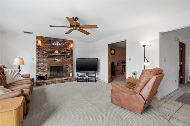 living room with ceiling fan, a fireplace, and light tile patterned flooring