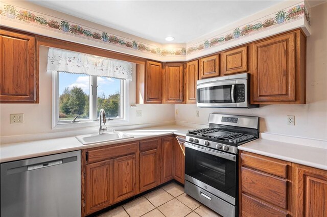 kitchen featuring light tile patterned flooring, appliances with stainless steel finishes, and sink