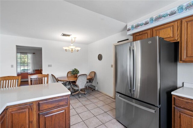 kitchen featuring a chandelier, stainless steel fridge, decorative light fixtures, and light tile patterned flooring