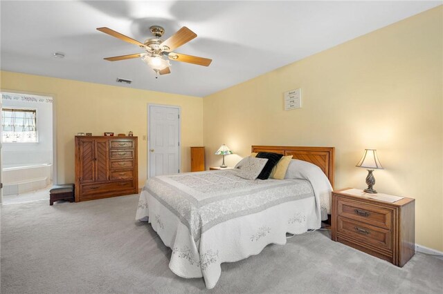 bedroom featuring ceiling fan, ensuite bathroom, and light carpet