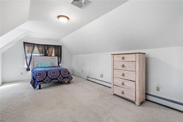 bedroom with vaulted ceiling, light carpet, and a baseboard heating unit