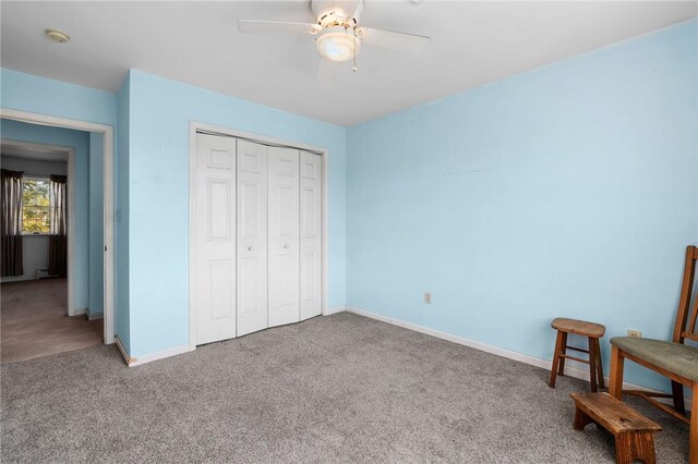 carpeted bedroom featuring ceiling fan and a closet