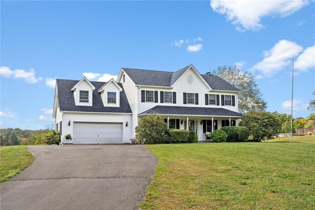 view of front of home featuring a front yard, a porch, and a garage