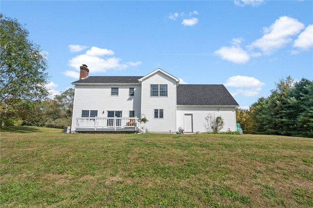 back of house featuring a wooden deck and a yard