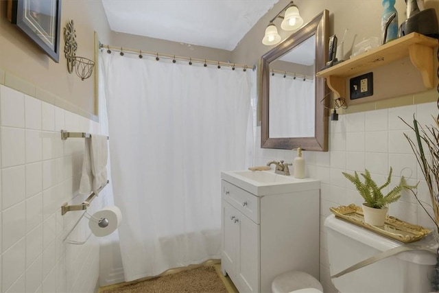 bathroom with vanity, toilet, tile walls, and curtained shower