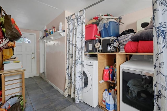 laundry room featuring dark tile patterned floors and washer and dryer