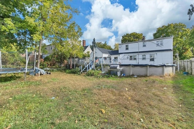 view of yard featuring a swimming pool side deck and a trampoline