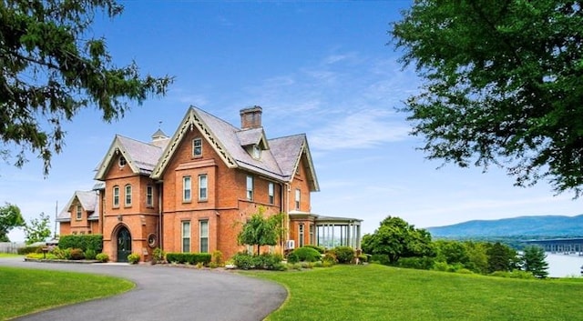 view of front of property with a mountain view and a front yard