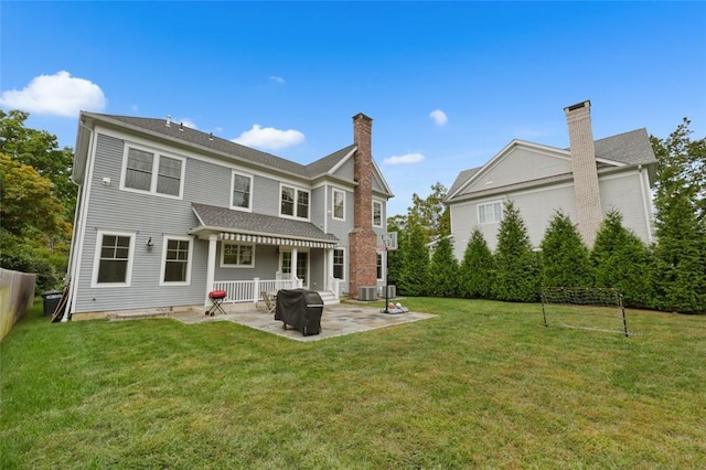 rear view of house featuring a patio area and a lawn