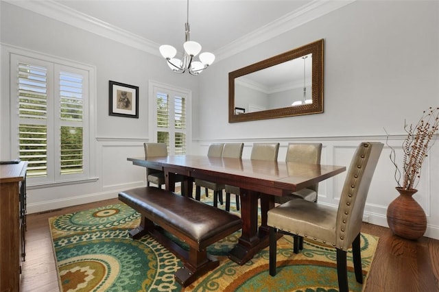 dining room with a notable chandelier, ornamental molding, and dark wood-type flooring