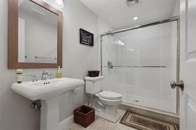 bathroom featuring tile patterned floors, sink, toilet, and walk in shower