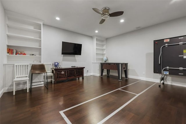 interior space with built in shelves, ceiling fan, and dark wood-type flooring