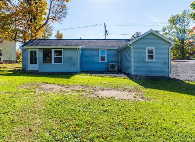 rear view of house with ac unit and a yard