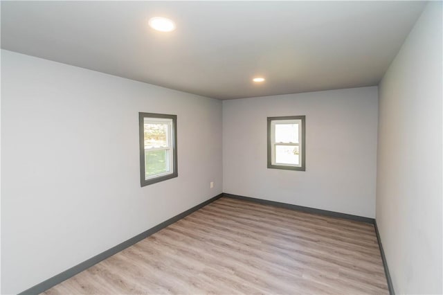 empty room with plenty of natural light and light hardwood / wood-style flooring