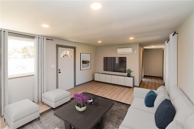 living room featuring hardwood / wood-style floors and a wall unit AC