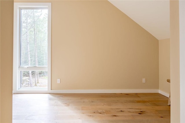 additional living space with plenty of natural light, light hardwood / wood-style floors, and lofted ceiling