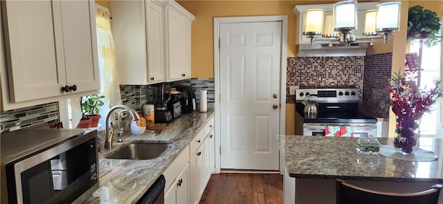 kitchen featuring appliances with stainless steel finishes, backsplash, sink, white cabinets, and dark hardwood / wood-style floors