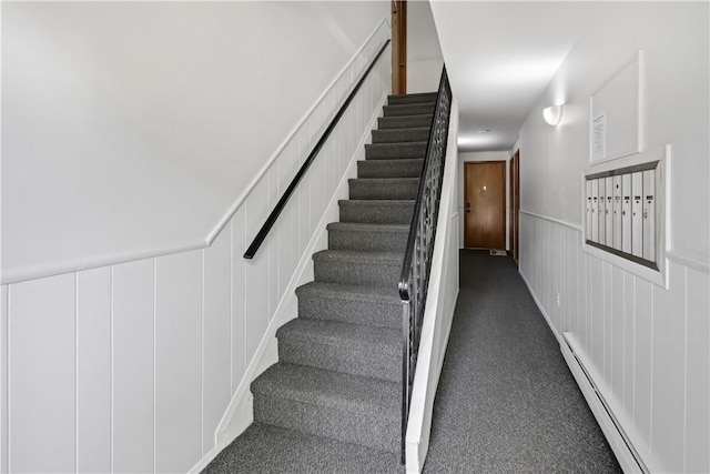 staircase featuring carpet floors, a mail area, and a baseboard heating unit