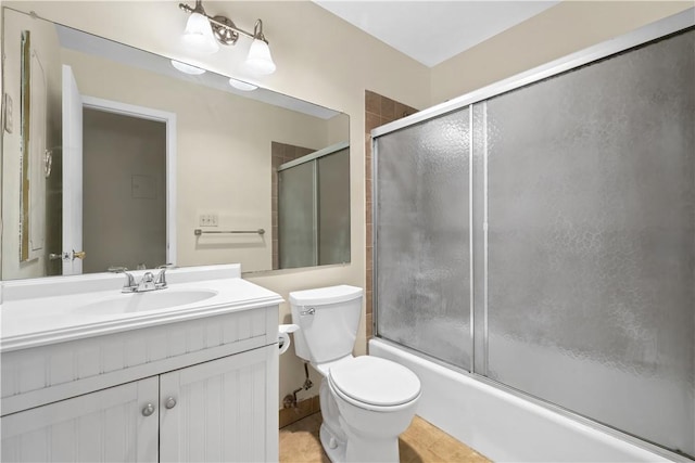 full bathroom featuring shower / bath combination with glass door, tile patterned floors, vanity, and toilet