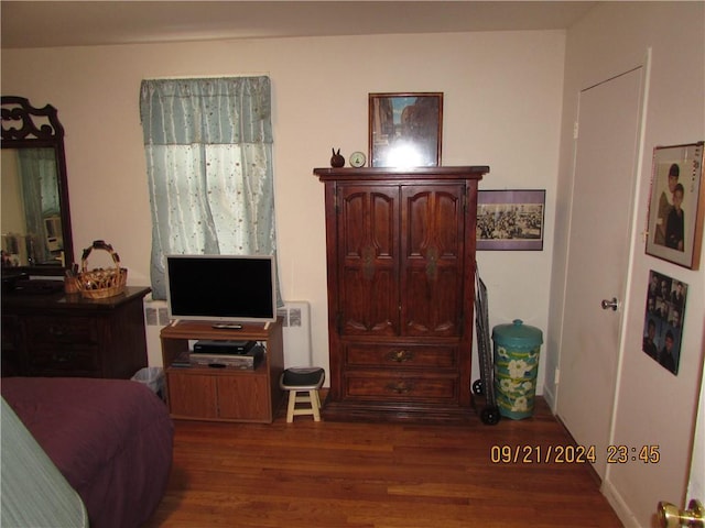 bedroom with radiator heating unit and dark hardwood / wood-style floors