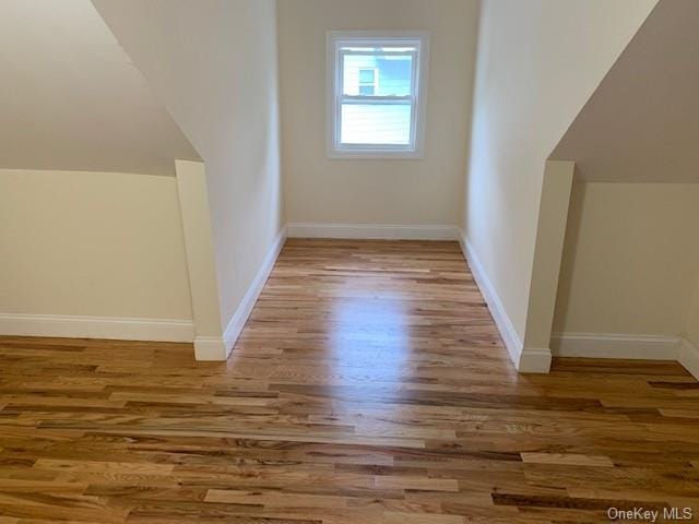 additional living space featuring hardwood / wood-style floors and vaulted ceiling