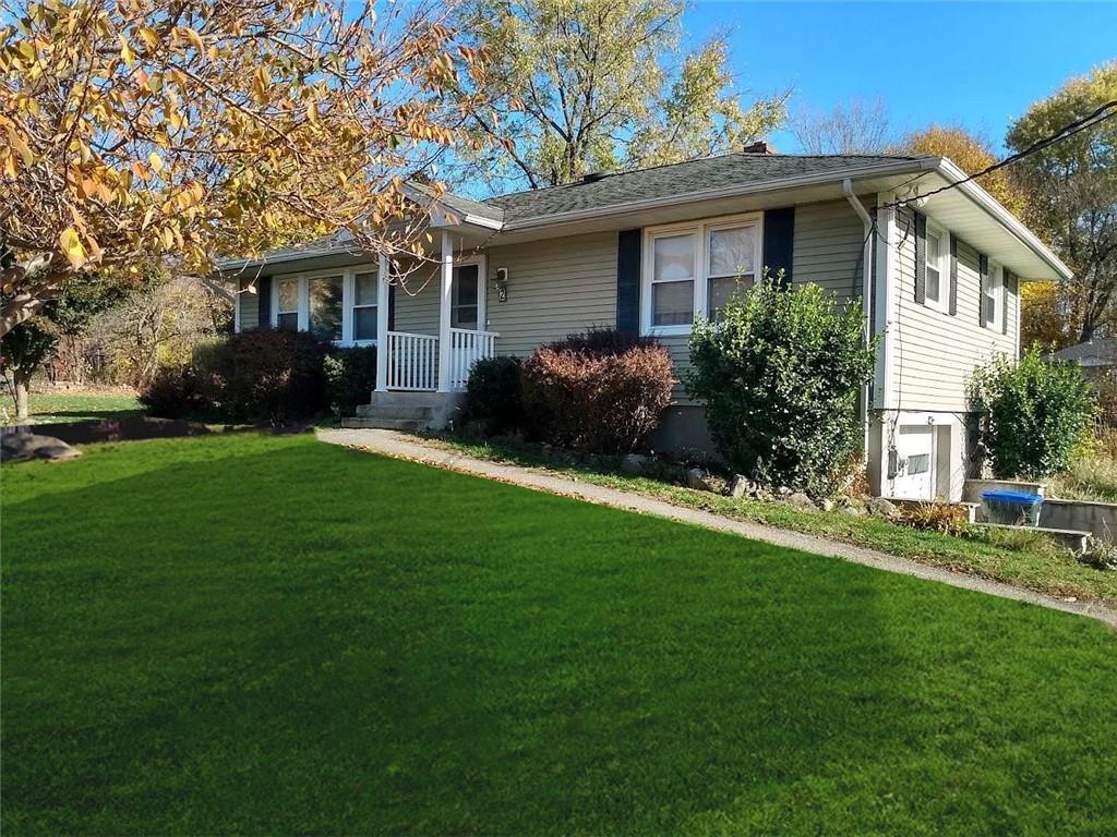 single story home featuring a porch and a front yard