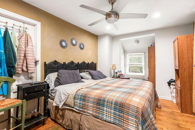 bedroom with light wood-type flooring, ceiling fan, and lofted ceiling