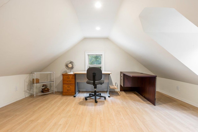 office with light wood-type flooring and lofted ceiling