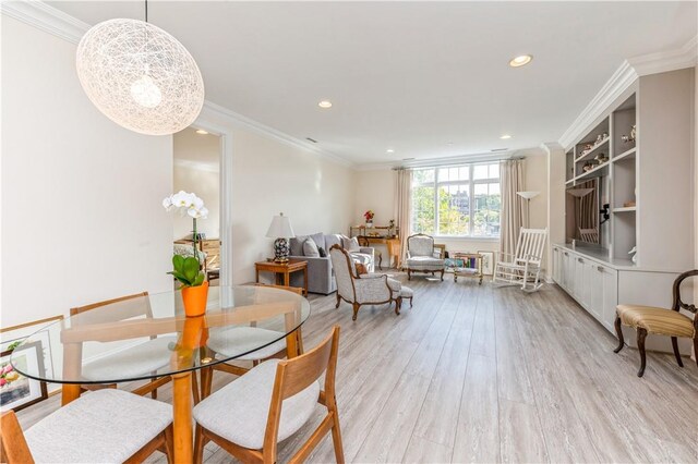 dining space with light hardwood / wood-style floors and ornamental molding