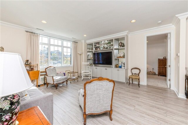 living room with light hardwood / wood-style floors and crown molding