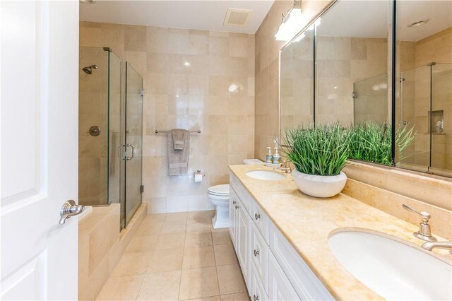 bathroom featuring an enclosed shower, vanity, tile walls, tile patterned flooring, and toilet