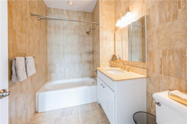 full bathroom featuring tile patterned flooring, tiled shower / bath combo, tile walls, and toilet
