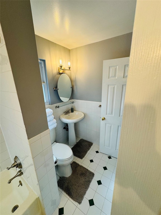 bathroom featuring tile patterned flooring, toilet, tile walls, and a tub