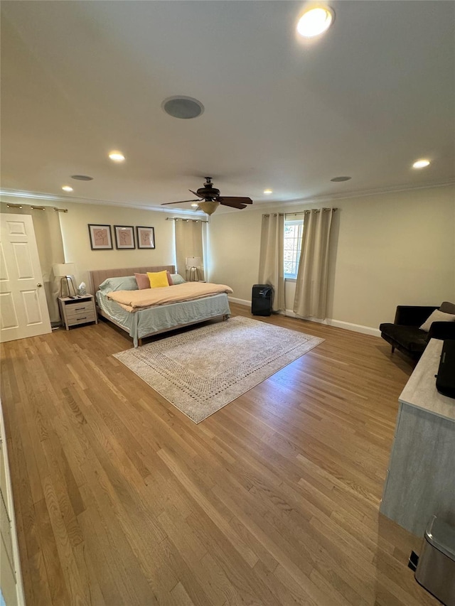 bedroom featuring light wood-type flooring, ceiling fan, and crown molding