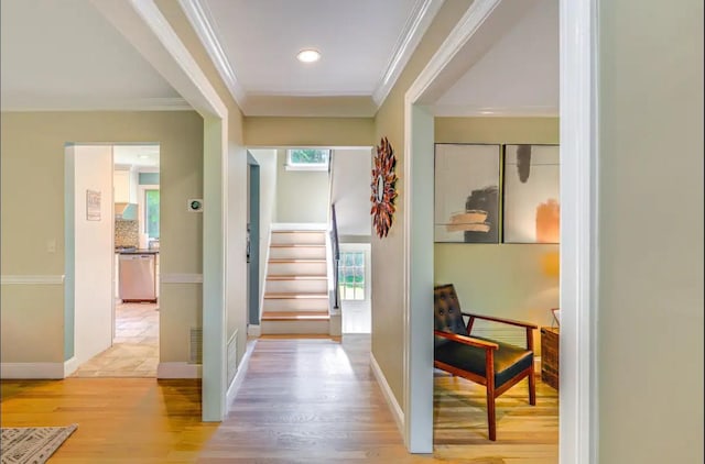 doorway featuring hardwood / wood-style floors, ornamental molding, and a healthy amount of sunlight