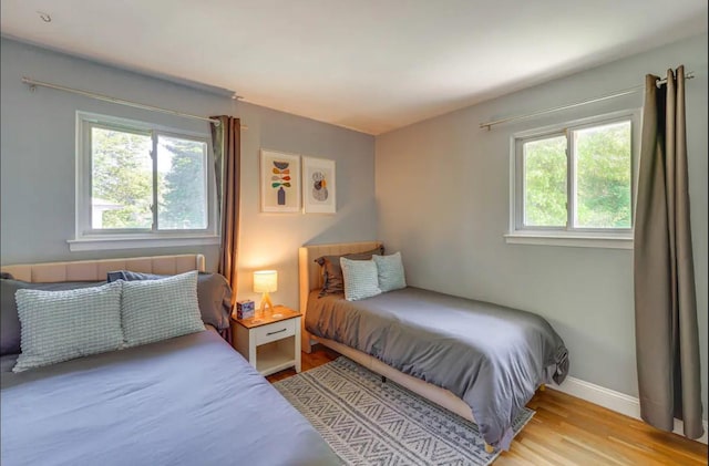 bedroom featuring multiple windows and light wood-type flooring