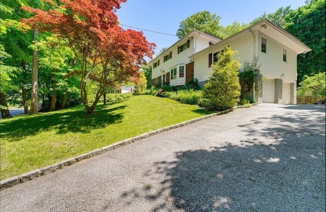 view of side of home with a yard and a garage