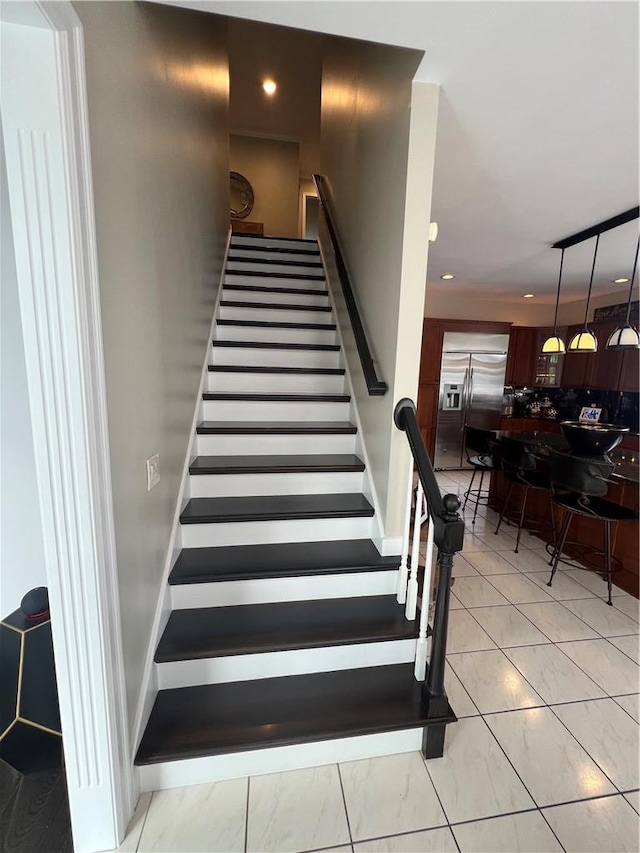 stairs featuring tile walls