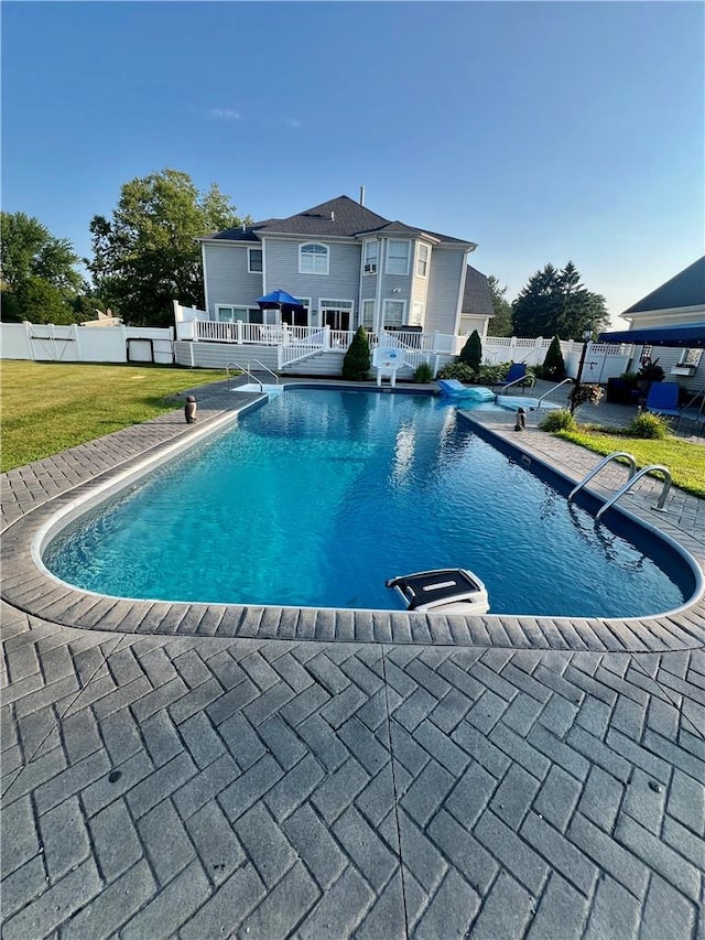 view of swimming pool with a lawn