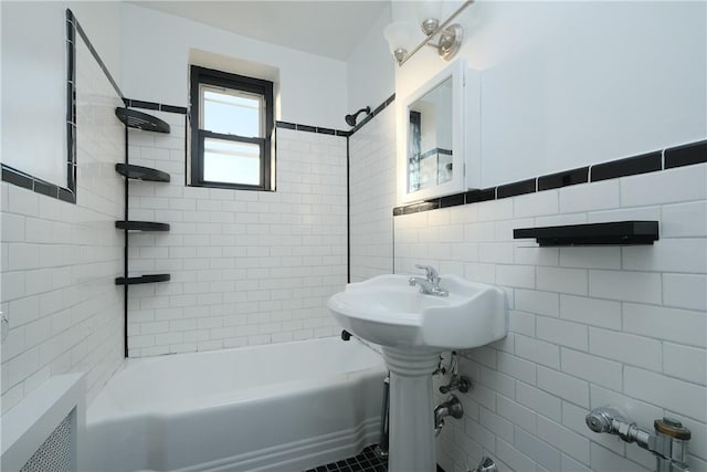 bathroom featuring tiled shower / bath combo and tile walls