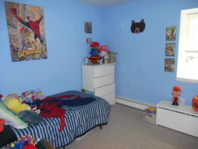 carpeted bedroom with baseboard heating and multiple windows