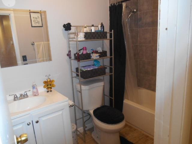 full bathroom with tile patterned floors, shower / bathtub combination with curtain, vanity, and toilet