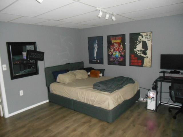 bedroom featuring a drop ceiling and dark hardwood / wood-style floors