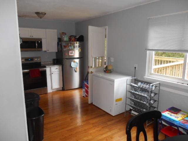 kitchen with white cabinetry, light hardwood / wood-style flooring, and appliances with stainless steel finishes