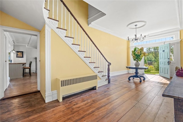 entryway with a notable chandelier, crown molding, radiator heating unit, and wood-type flooring