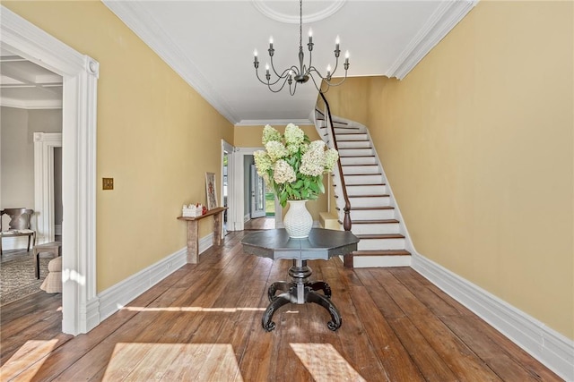 entryway featuring an inviting chandelier, ornamental molding, and wood-type flooring